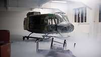 Ein Hubschrauber steht in einem Raum mit Nebel.