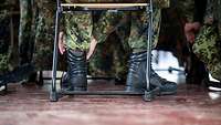 Einer der uniformierten Teilnehmenden richtet sich den Stiefel.