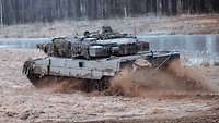 Ein Kampfpanzer beschleunigt im Gelände