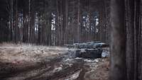 Ein Kampfpanzer überwacht aus der Fahrt das Vorgelände