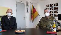 Generalmajor André Bodemann und Dr. Wolfgang Schäuble an einem Tisch
