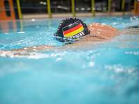 Trainieren für die Invictus Games 2022 Ein Mann schwimmt mit Deutschland-Badekappe in einem Schwimmbecken.