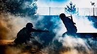 Zwei Soldaten überwinden gemeinsam ein Hindernis