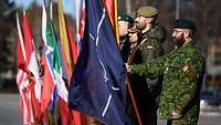 Soldaten vieler Nationen sind mit ihren Fahnen angetreten.