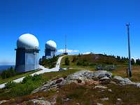 Großer Arber Zwei Gebäude mit einer runden Kuppel in der sich ein Radar verbirgt stehen auf einer Bergspitze.