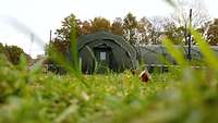 Der Eingang eines mobilen Gefechtsstandes der Bundeswehr aus dem Gras heraus fotografiert