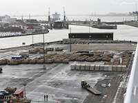 Anlandung des Materials Viele Panzer und Container stehen aufgereiht an einem Hafen
