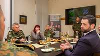 Ein Rabbiner spricht an einem gedeckten Tisch mit Soldaten.