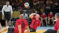 Ein deutscher Volleyballspieler spielt den Ball beim Sitzvolleyball