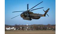 Ein Hubschrauber vom Typ CH-53 fliegt dicht über dem Boden.
