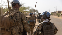 Soldaten in Schutzweste gehen durch eine Ortschaft in Mali