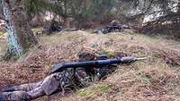 Soldaten liegen auf dem Waldboden.