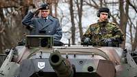 Zwei Soldaten schauen aus der Luke eines fahrenden Panzers.
