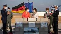 Annegret Kramp-Karrenbauer and Florence Parly stand by a small wall where they laid the foundation stone.