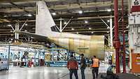 The rear fuselage of the C-130J with horizontal and vertical stabilizer in a Lockheed Martin production hall.