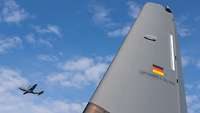 In the foreground, the fin of the German C-130J can be seen; in the sky above, a French C-130J.