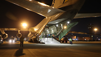 Ein Transportflugzeug Antonow AN-124 steht mit offenem Laderaum auf einem Flugfeld