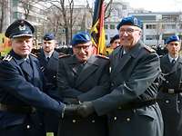 Gratulation für alt und neu Drei Soldaten stehen nebeneinander und gratulieren sich. Im Hintergrund drei weitere Soldaten