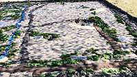 In einem Sandkasten sind Straßen, Wege und Waldstücke maßstabsgerecht dargestellt.