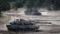 Zwei Kampfpanzer kurz nach dem Schuss auf der Schießbahn.