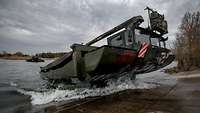 Eine Amphibie fährt aus dem Wasser.