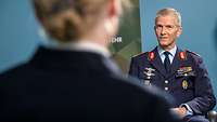 Generalleutnant Martin Schelleis sitzt einer Soldatin gegenüber und spricht mit ihr