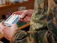 Eine Person in Uniform hält eine geöffnete Tablettenpackung mit der Aufschrift Adminimum