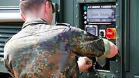 Soldat arbeitet an der Satcomanlage.