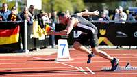 Ein Mann beim Start eines 100 Meter Laufes