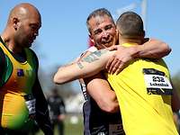 Invictus Games 2022 Sportler Zwei Männer umarmen sich. Einer steht daneben
