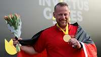 Diskuswerfer Alex trägt seine Goldmedaille um den Hals