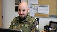 Korvettenkapitän Benjamin R. sitzt am Schreibtisch. 