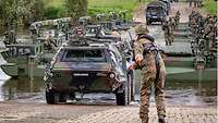 Militärfahrzeuge überqueren auf einer Schnellbrücke die Weser.