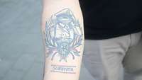 Tattoo Survivor Ein Unterarm Tattoo, dass einen salutierenden Soldaten mit Verband um den Kopf zeigt