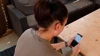 Eine Soldatin hält ein Handy in den Händen