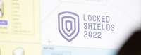 Netzplan Locked Shields 2022 Ein Bildschirm zeigt den Plan aller angeschlossenen Systeme. Davor steht ein Soldat.