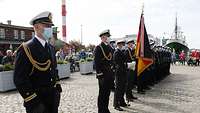 Menschen in schwarzer Uniform sind in gerader Linie angetreten.