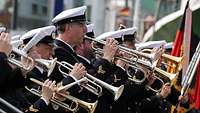 Menschen in Uniform spielen Musikinstrumente.