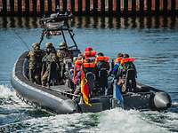 Evakuierungsübung Schneller Adler 2022 Soldaten fahren mit Zivilisten in einem Speedboot.