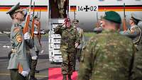 Ein deutscher General steigt aus einem Flugzeug und wird von einem slowakischen General empfangen. 