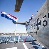 Eine waagerecht rot-weiß-blau gestreifte Flagge weht am Heck eines Schiffs.