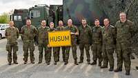 Inspekteur der Luftwaffe mit FlaRak-Soldaten in Sliač Generalleutnant Gehartz beim Erinnerungsfoto mit der Truppe. Sie halten ein Schild mit dem Schriftzug „Husum“.