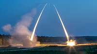 Zwei Raketenwerfer MARS II schießen jeweils eine Rakete in den Nachthimmel ab