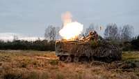 Ein 120 Millimeter Mörser auf einem leicht gepanzerten M113-Transportwagen schießt scharf auf einem Feld