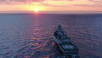 Eine Korvette F 261 Magdeburg fährt über die offene See in den Sonnenuntergang