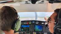 Ein Fluglehrer erklärt beim Start in Montpellier dem Schüler etwas im Cockpit.