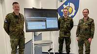 Drei Soldaten neben einem Monitor mit der geöffneten Anwendung.
