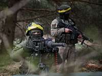 Litauische Soldaten als professionelle Übungsgegner Zwei litauische Soldaten stehen mit ihren Waffen im Anschlag im Wald.