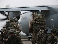 Fallschirmjäger verlassen das Flugfeld Mehrere Soldaten laufen auf einem Flugfeld zu einem Flugzeug.