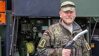 Ein Soldat mit einer Zapfpistole blickt in die Kamera